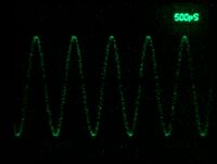 7104 recording 1 GHz sine, single shot at 500 ps/Div. Camera: Nikon D7000, 50 mm f/1.4, ISO 3200, 1/2 s. CRT filter not removed. CRT amplification loss is evident around the center line.